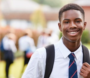 A school boy in uniform wearing a tie outside