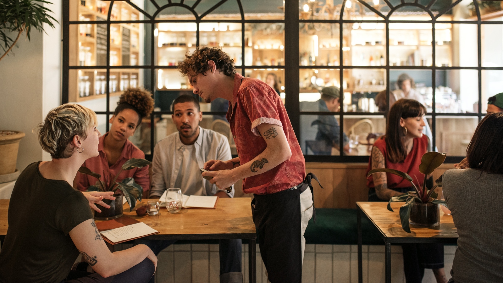 People sat at a table ordering food from menus