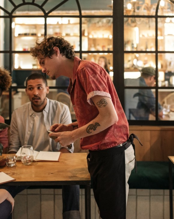 People sat at a table ordering food from menus