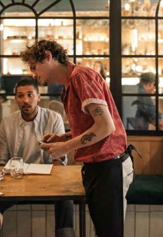 People sat at a table ordering food from menus