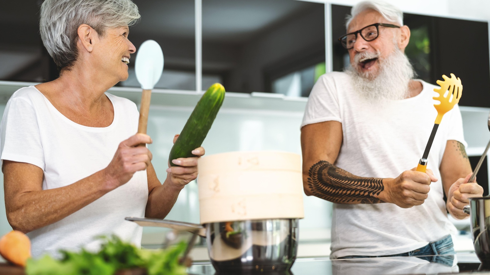 happy senior couple having fun cooking together in the kitchen