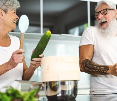 happy senior couple having fun cooking together in the kitchen