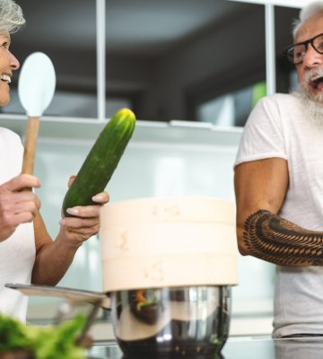 happy senior couple having fun cooking together in the kitchen