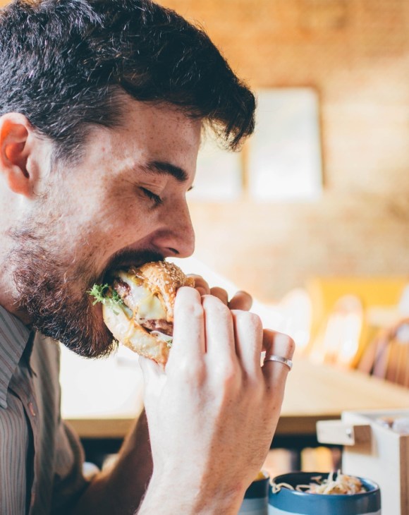 Man eating meat burger