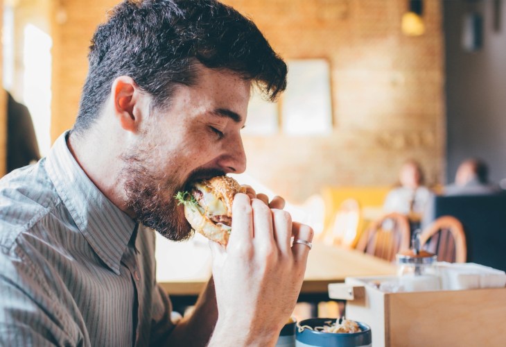 Man eating meat burger