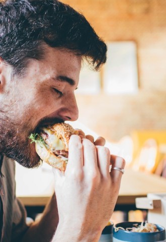 Man eating meat burger