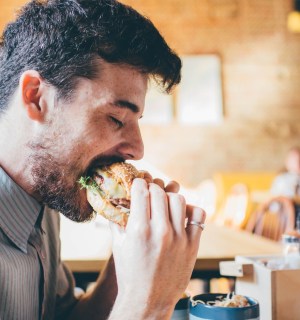 Man eating meat burger