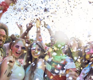 Friends celebrating festival under shower of confetti