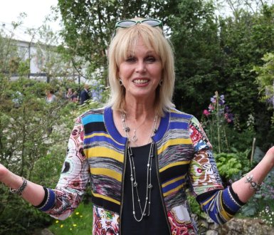 joanna lumley standing in a garden holding her arms out