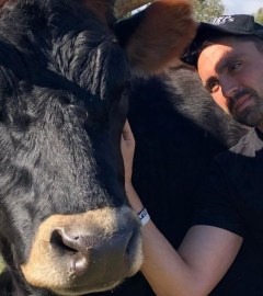 Vegan activist Joey Carbstrong with a cow