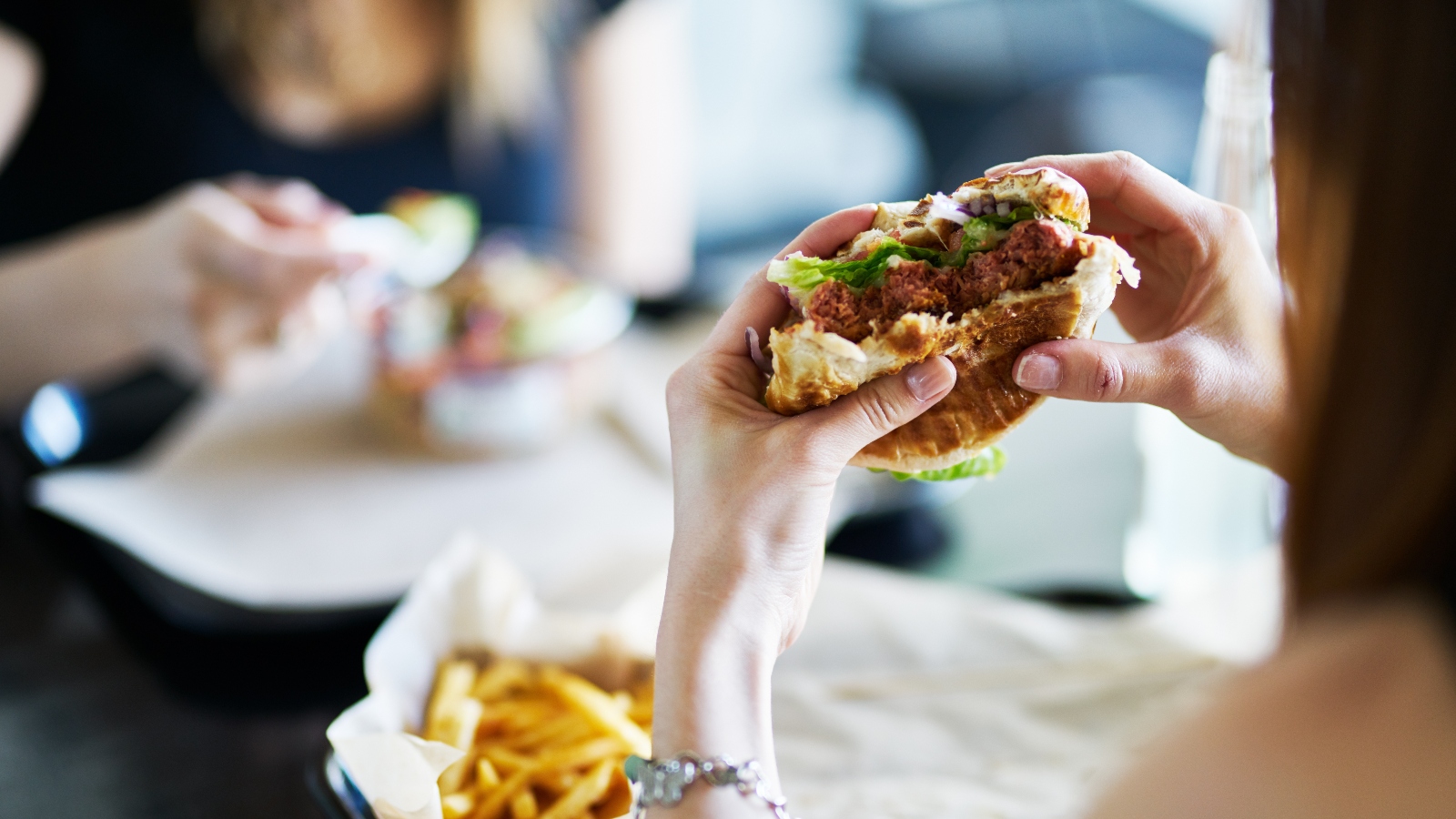 A person holding up a half eaten burger