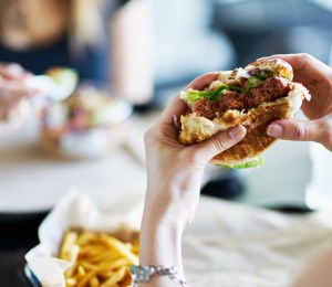 A person holding up a half eaten burger