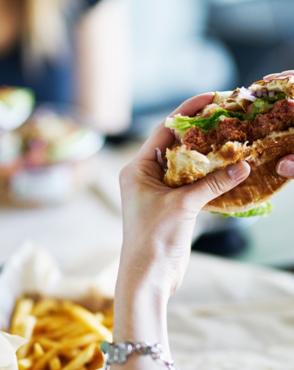 A person holding up a half eaten burger