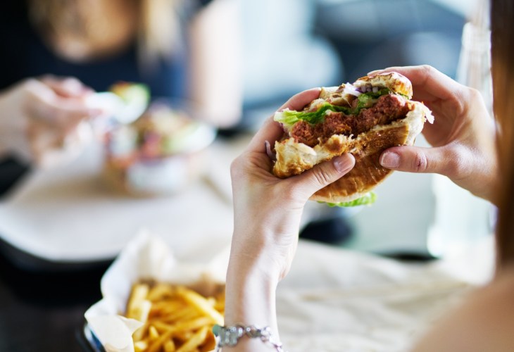 A person holding up a half eaten burger