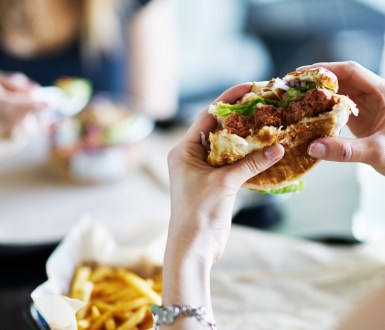 A person holding up a half eaten burger