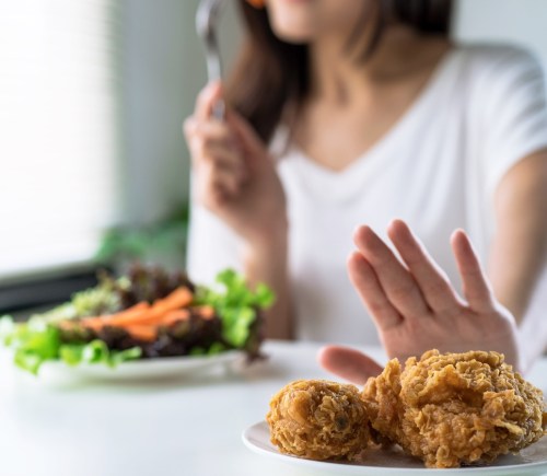 Person pushing meat away to eat vegan food