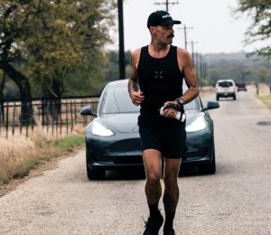 robbie balenger running in front of a tesla model 3 car