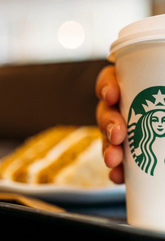 Person holding a Starbucks coffee cup