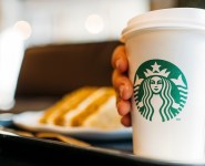 Person holding a Starbucks coffee cup