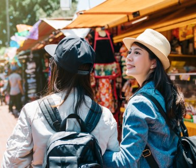 Two friends walking through an outdoor market