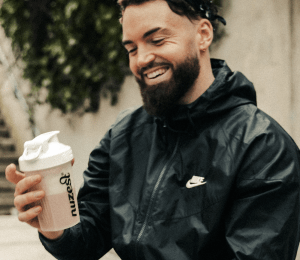 Man sits with protein shaker